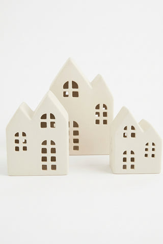 Set of three beige ceramic house-shaped objects on a white background