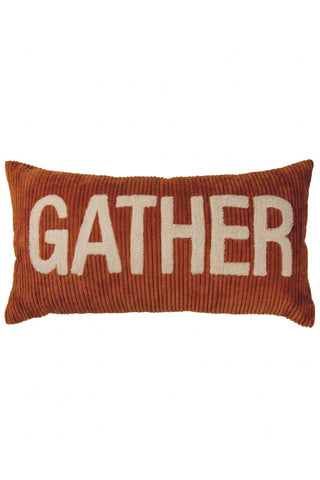 A rectangular rust-orange corduroy throw pillow with the word 'GATHER' woven in large cream-colored letters across the front, shown against a plain white background.