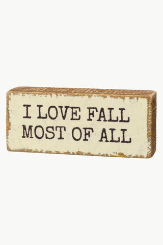 Wooden block with 'I LOVE FALL MOST OF ALL' text on a white background