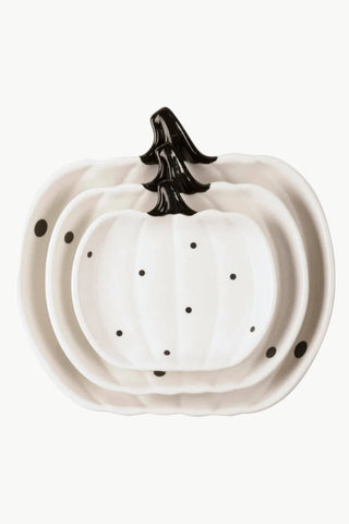 Three nested white ceramic pumpkin-shaped serving plates with black polka dots and a black stem detail, shown on a plain white background.