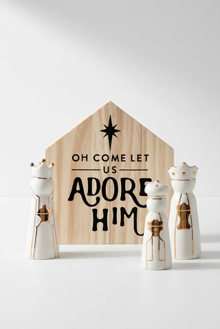 Decorative set with wooden sign and three white figurines on a white background