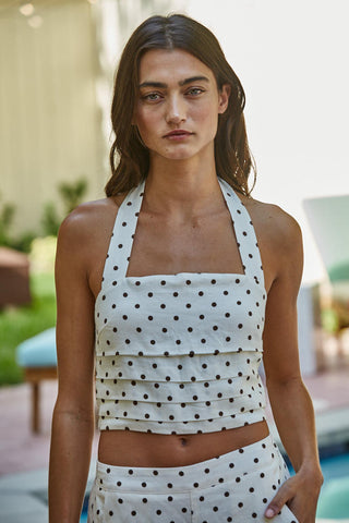 Woman wearing a polka dot top and skirt in an outdoor setting