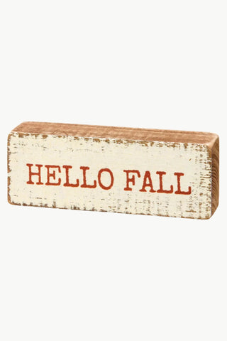 Wooden block with 'HELLO FALL' text on a white background