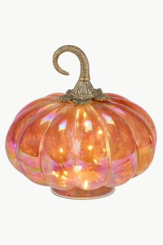 An iridescent orange glass pumpkin decoration with a textured metallic gold stem and base, shown against a plain white background.